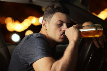 Man drinking alcohol in car