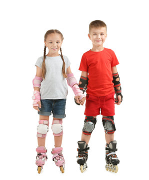 Cute boy and girl on roller skates against white background