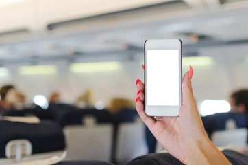 Woman showing mobile to camera in airplane