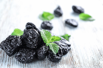 Tasty dried plums on wooden table