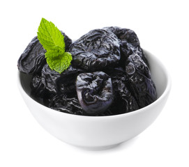 Bowl with tasty dried plums on white background