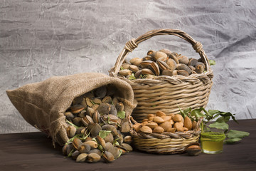 Almonds over rustic wooden board. / Almonds over a rustic wooden board. Rustic sack and basket. Nutcracker and almond oil. 