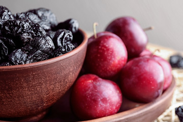 Tasty dried and fresh plums on table, closeup