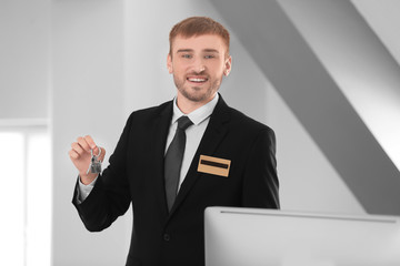Male receptionist with room key in hotel