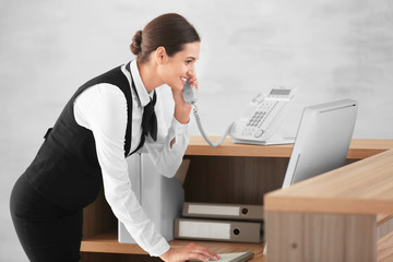 Female receptionist talking on phone in hotel