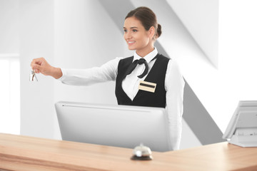 Female receptionist with room key in hotel