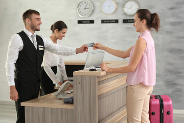 Woman paying for hotel room at reception