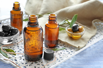 Glass bottles with olive oil on white tray