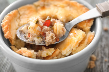 Spoon and ramekin with delicious meat pie, closeup