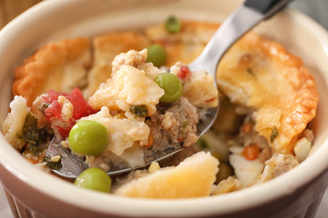 Spoon and ramekin with delicious meat pie, closeup