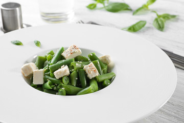 Plate with delicious green beans salad on kitchen table, closeup
