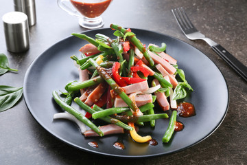 Plate with delicious green beans salad on kitchen table
