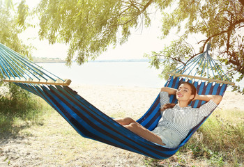 Attractive woman relaxing in hammock outdoors