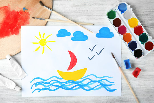 Child's painting of sailing ship on table