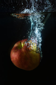 A red apple in a stream of water
