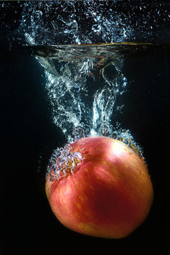A red apple in a stream of water