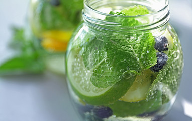 Jar of infused water with fruits on table, closeup