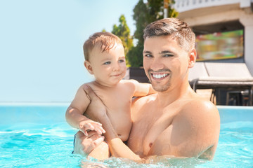 Fototapeta na wymiar Child swimming lesson. Cute little boy with father in pool