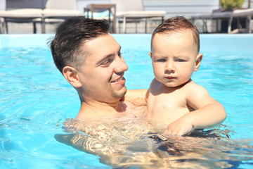 Child swimming lesson. Cute little boy learning to swim with father in pool