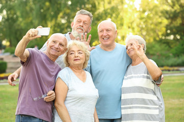 Group of elderly people taking selfie in park