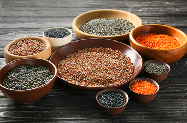 Bowls with different lentils on wooden table