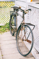 Fototapeta na wymiar old and rusty bike abandoned outside a wooden fence