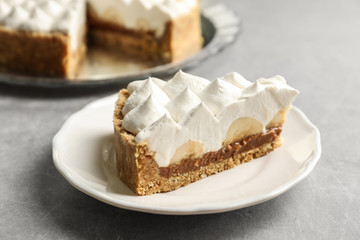 Plate with piece of delicious banana cake on table
