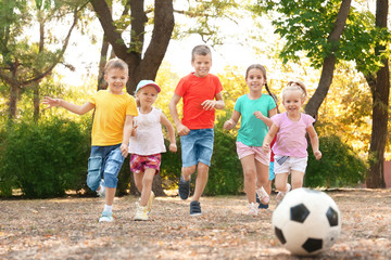 Fototapeta na wymiar Cute children playing with ball in park