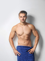 Fototapeta premium Sexy man wrapped in towel on white background