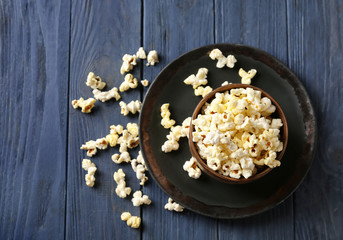 Bowl with popcorn on wooden table