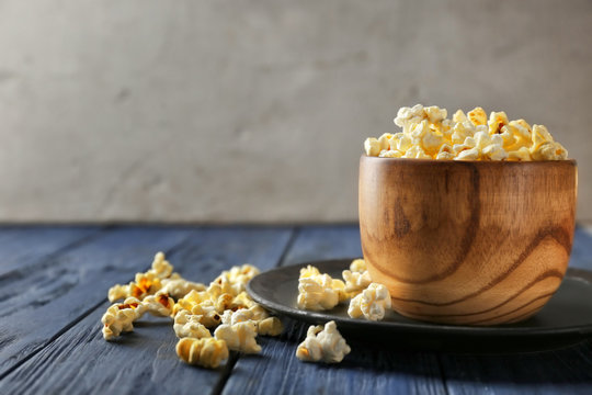 Bowl with popcorn on wooden table