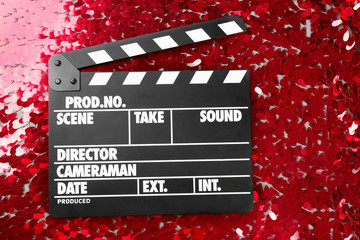 Movie clapper on red bright background