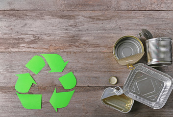 Recycling sign and garbage on wooden background