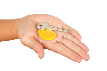 the key with a round yellow keychain on the palm hand