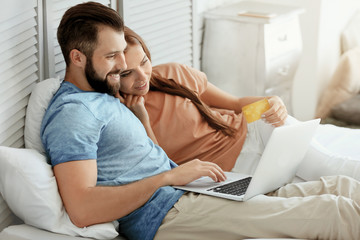 Obraz premium Young couple with laptop at home. Internet shopping concept
