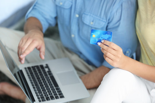 Couple with laptop and credit card. Internet shopping concept