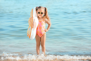 Fototapeta na wymiar Cute little girl on sea beach