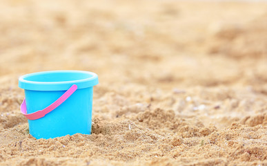 Children's beach bucket on sand