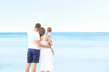 Happy couple with little son on beach