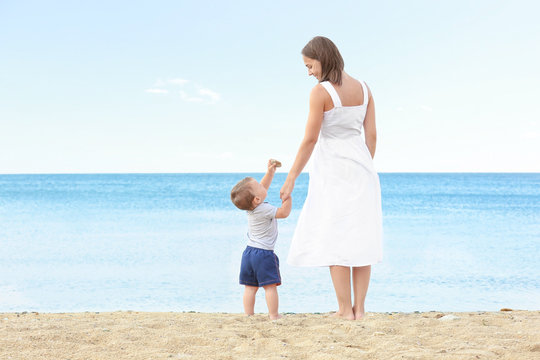 Happy mother with little son on beach