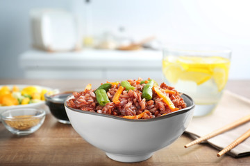 Dish with brown rice on table