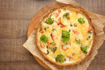 Tasty salmon quiche on wooden board