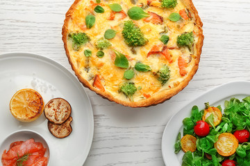 Tasty salmon quiche on table