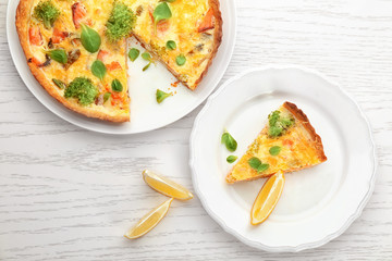 Tasty salmon quiche on table