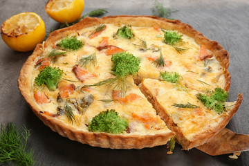 Tasty salmon quiche on table