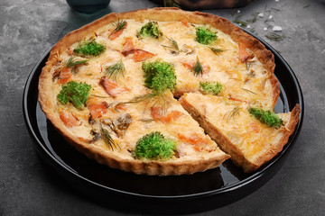 Tasty salmon quiche on table
