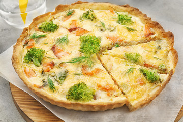 Tasty salmon quiche on wooden board