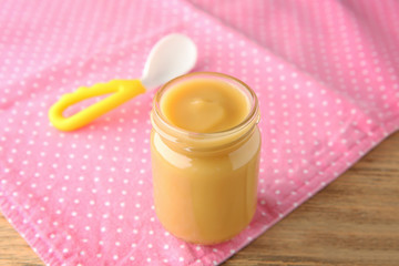 Jar of tasty baby food on table