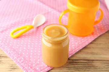 Jar of tasty baby food on table