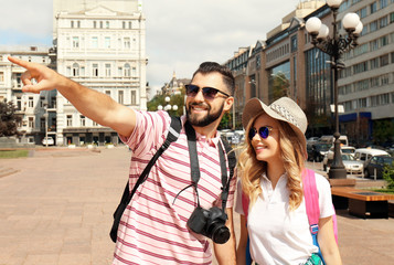 Happy young tourists walking on street in city